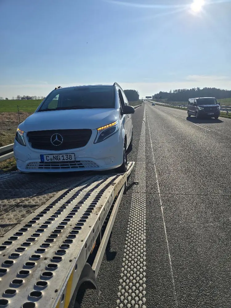 Mercedes Vito wjechany na platformę lawety przy drodze ekspresowej w słoneczny dzień.